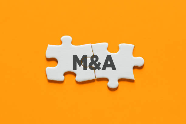 Connected puzzle pieces with the acronym M&A. Merger and acquisition in business concept.