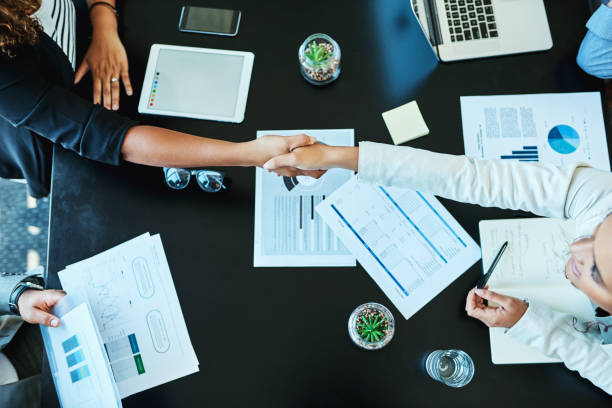 Shot of businesspeople shaking hands during a meeting in an office